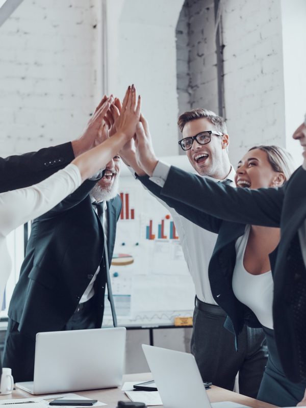 cheerful-business-team-giving-each-other-high-five-to-success-while-working-in-the-modern-office.jpg